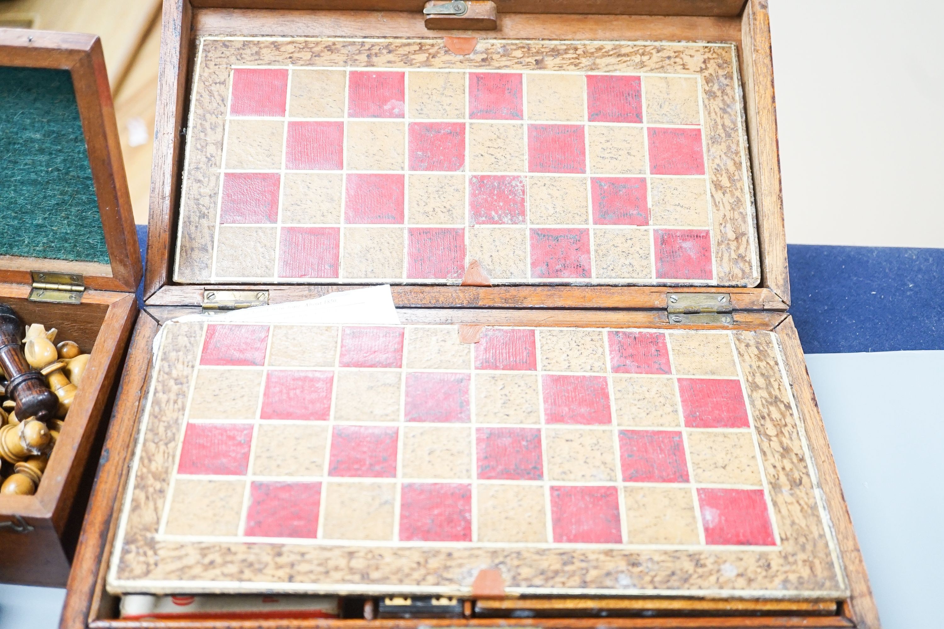 A Victorian brass inset mahogany games box, fitted with solitaire, cribbage, chessmen, draughts etc., 33cm, a turned and stained bone chess set, another games box containing chessmen and draughts
